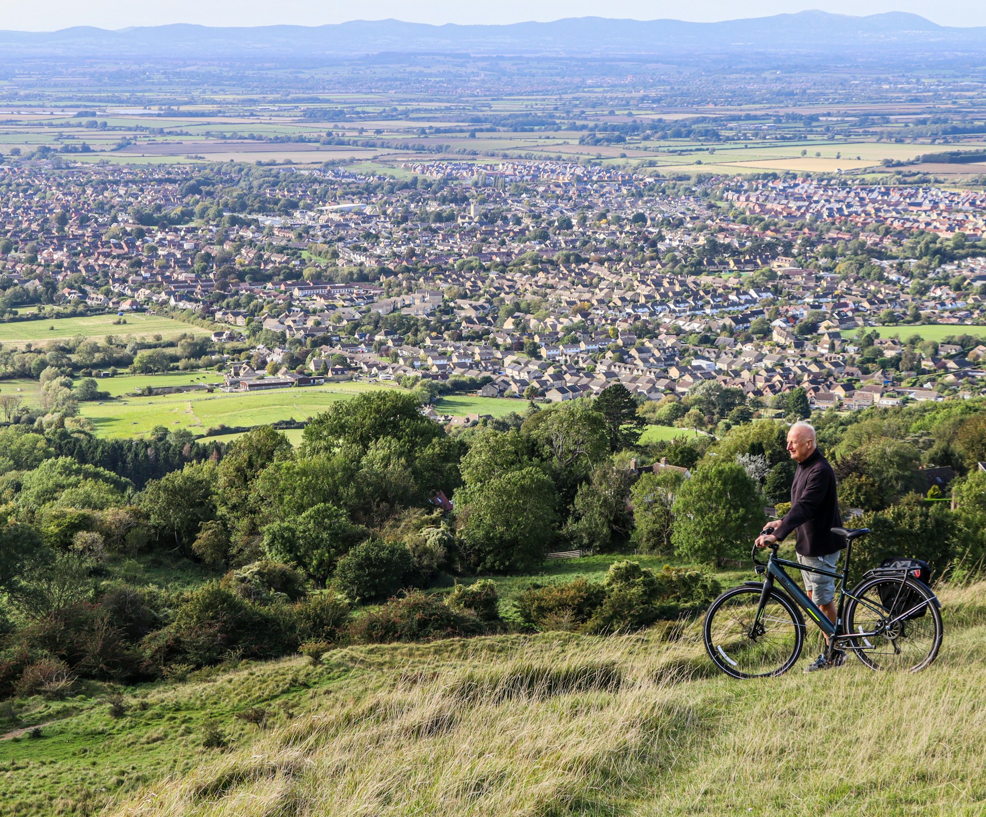 Cyclist overlooking the countryside from a hilltop